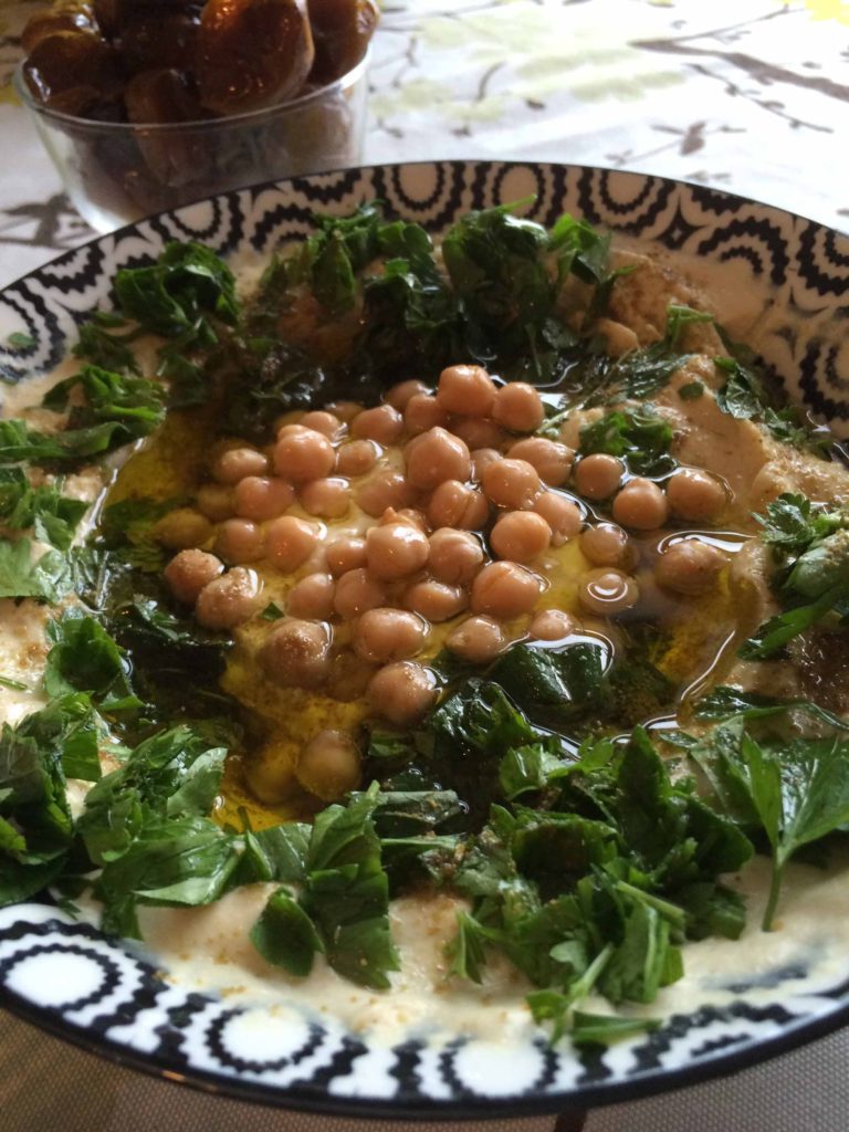 bowl of freshly made hummus with chickpeas on top