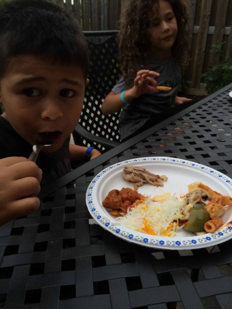 Leah and Jaffer sitting in the backyard with a plate of iftar food on the table