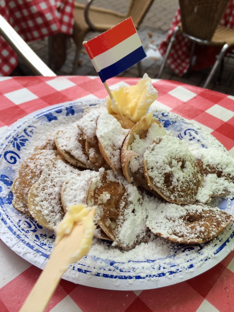 plate of poffertjes dusted with powdered sugar- dutch foods to try in amsterdam