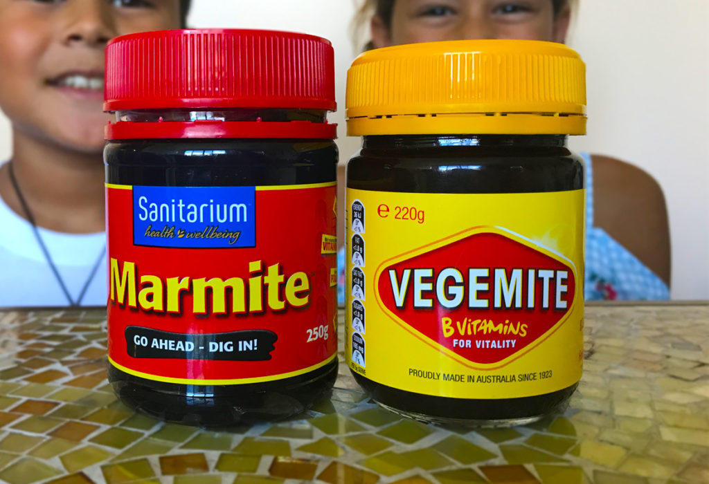 bottle of red marmite next to a yellow bottle of vegemite