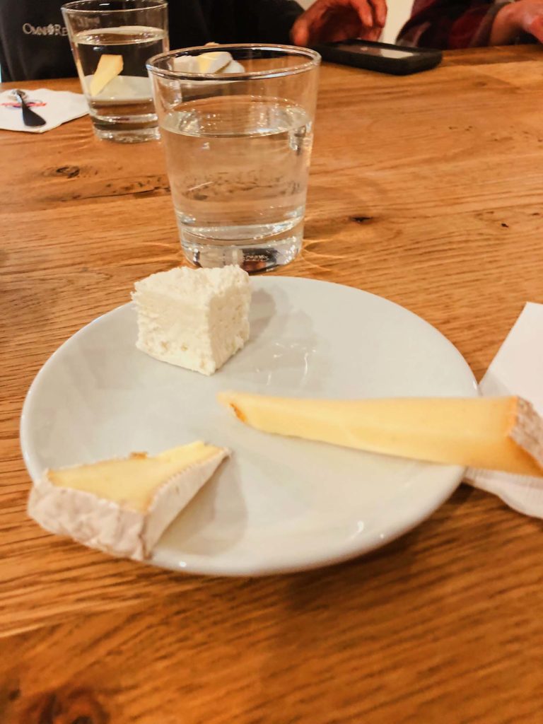 plate of three types of French cheese with glass of water in the back