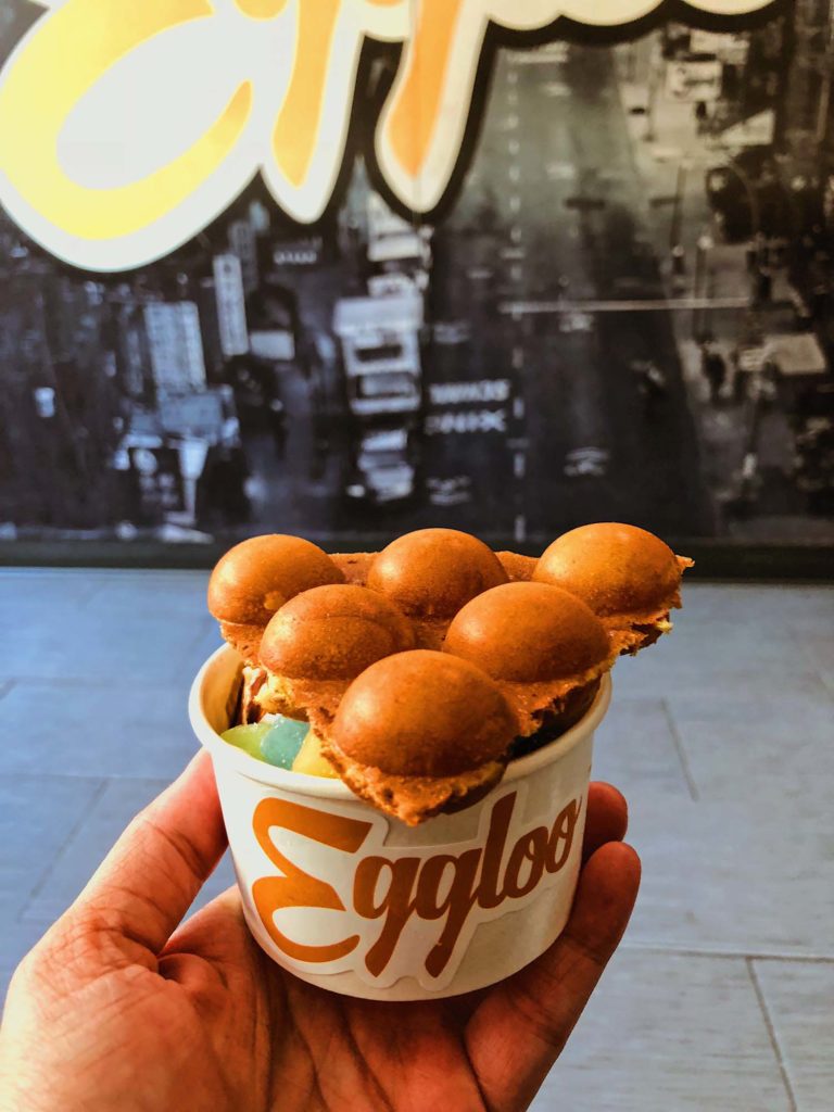 picture of eggloo sundae being held up in front of a large Eggloo sign